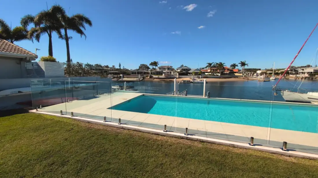 Frameless glass pool fence overlooking the canal